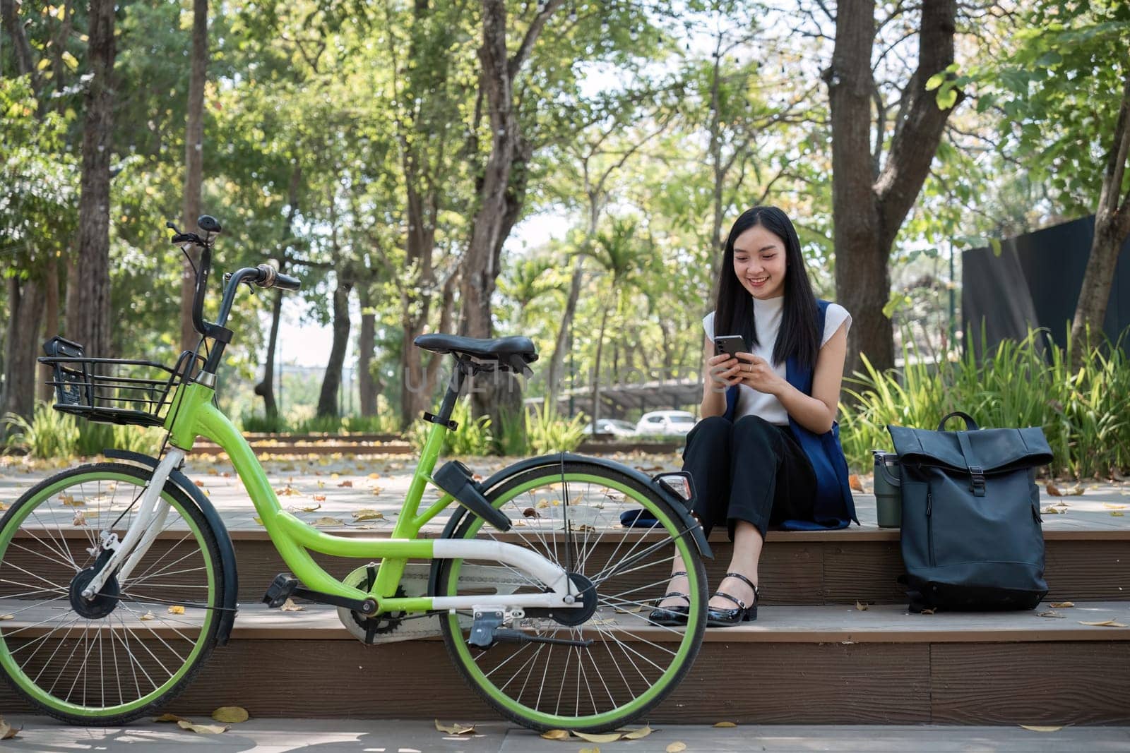 Asian business woman sitting and working in a nature park Travel by bicycle to save the environment by wichayada