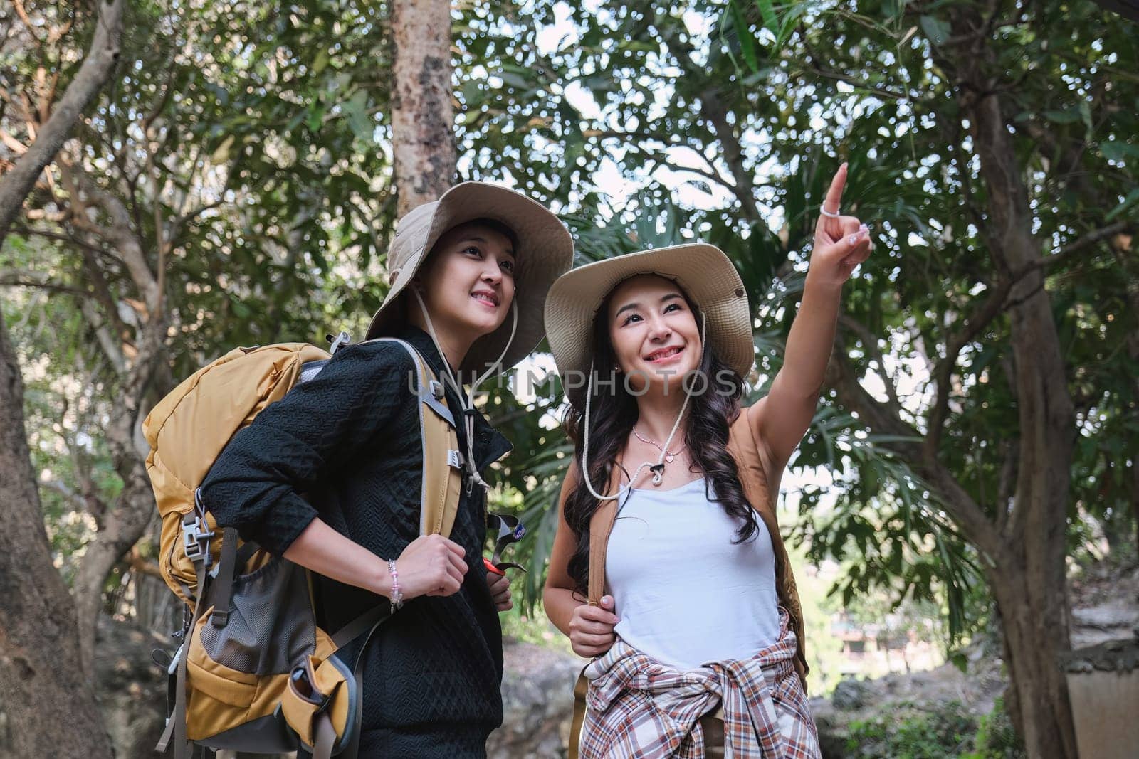 Asian couple hiking in nature Studying the hiking route following the signs..