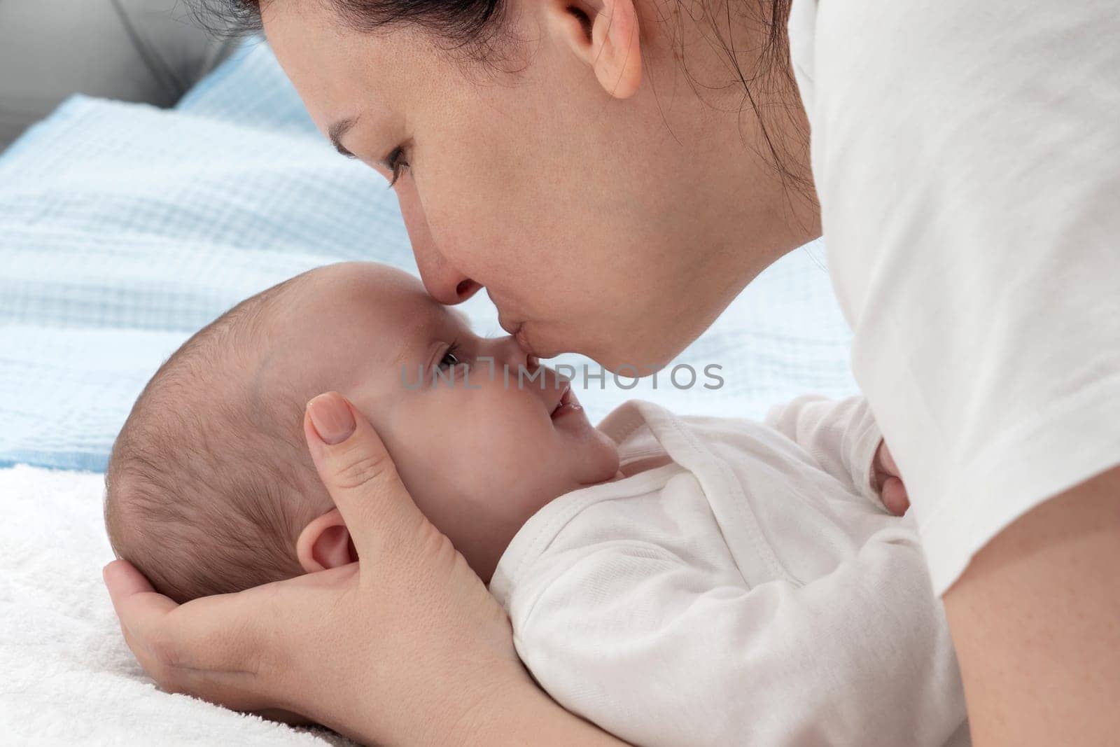 The woman lovingly kissed her babys nose, a comforting gesture of happiness and love, as they