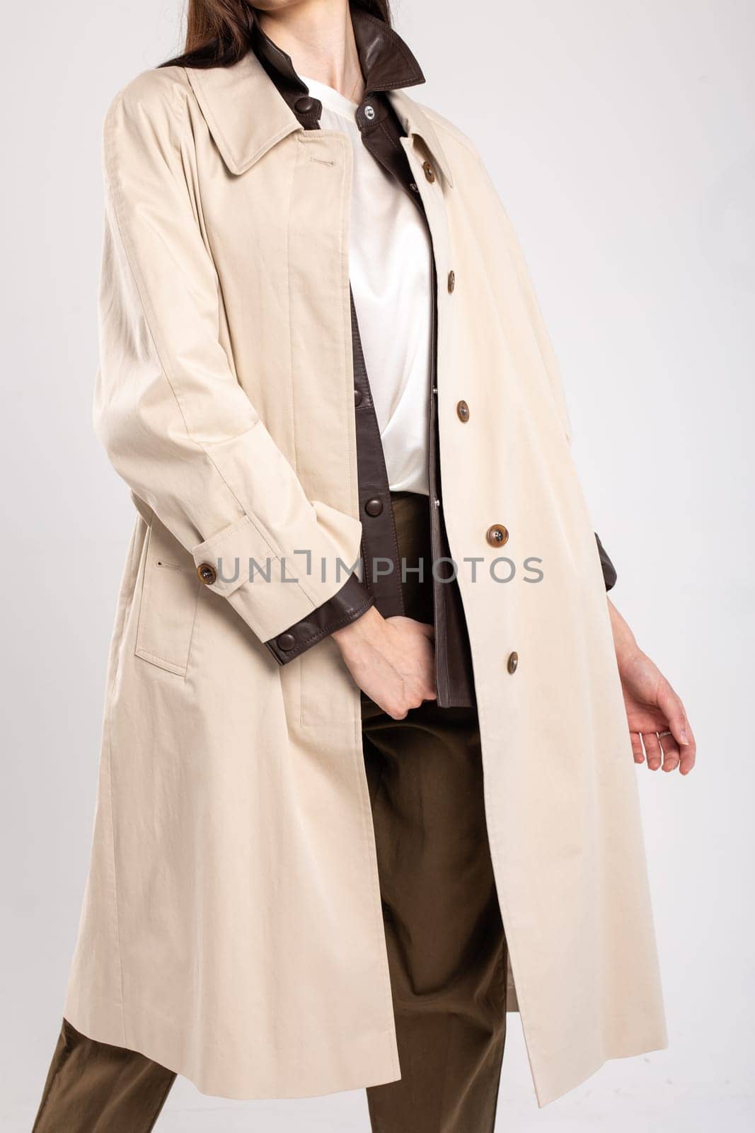 A sophisticated and timeless look for any occasion, this beige trench coat features a sleek and clean design with a hint of luxury.