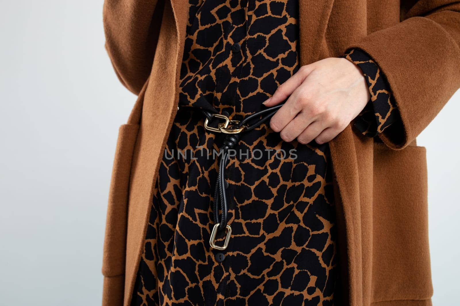 Fashion model in a brown coat and animal print dress. by Pukhovskiy