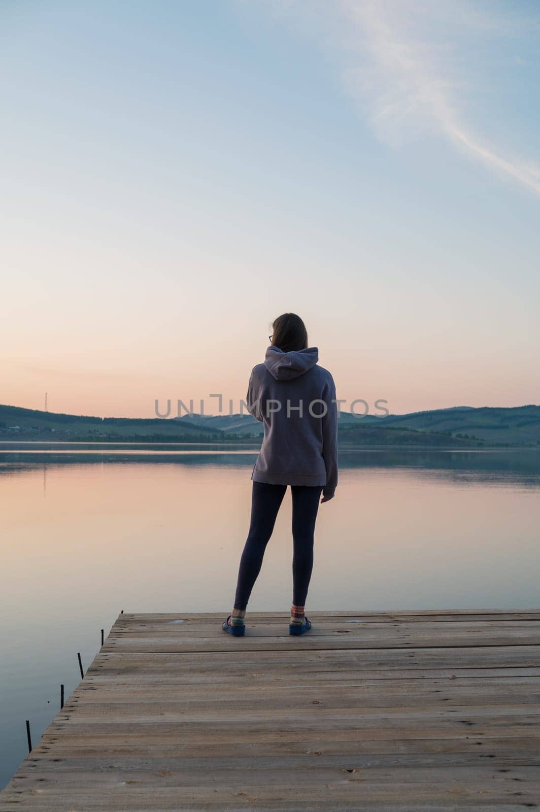 Woman on the pier at lake, closeup portrait, summer sunset