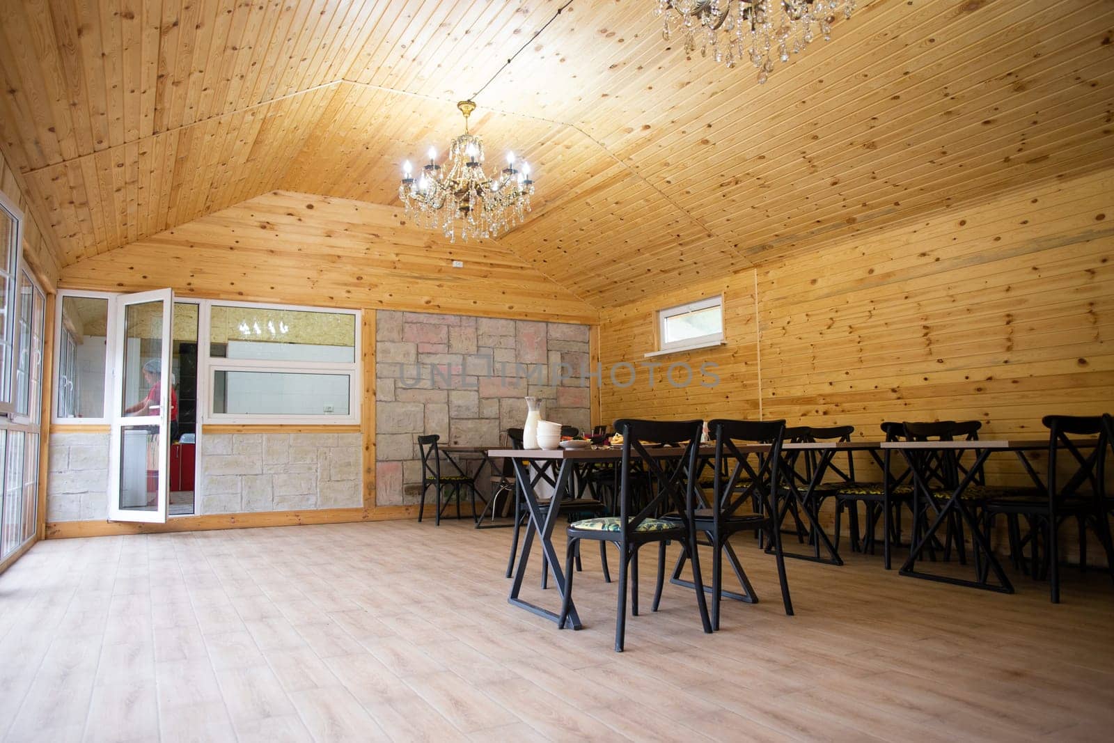 Rustic wooden interior of a cozy restaurant with tables and chairs by Pukhovskiy