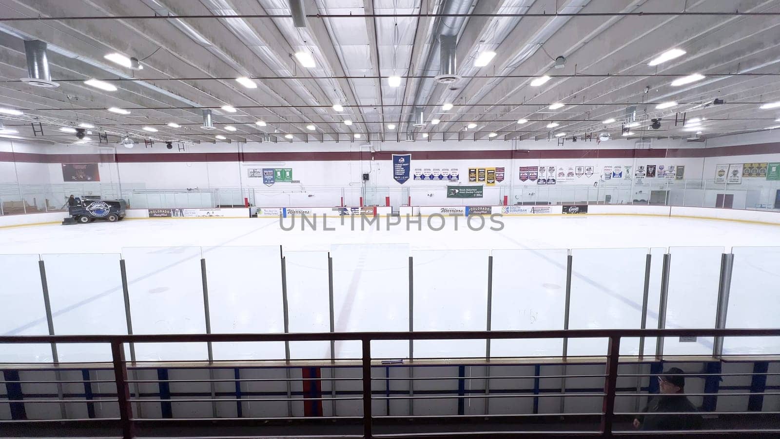 Denver, Colorado, USA-February 17, 2024-ice resurfacer moves across the surface of an empty hockey rink, surrounded by banners and seating, preparing the ice for athletes and skaters.