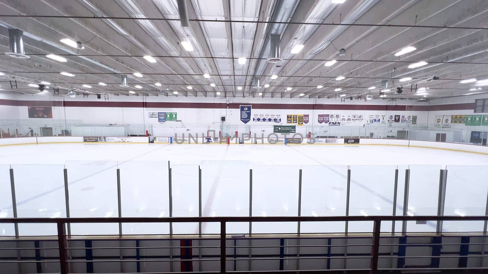 Denver, Colorado, USA-February 17, 2024-ice resurfacer moves across the surface of an empty hockey rink, surrounded by banners and seating, preparing the ice for athletes and skaters.