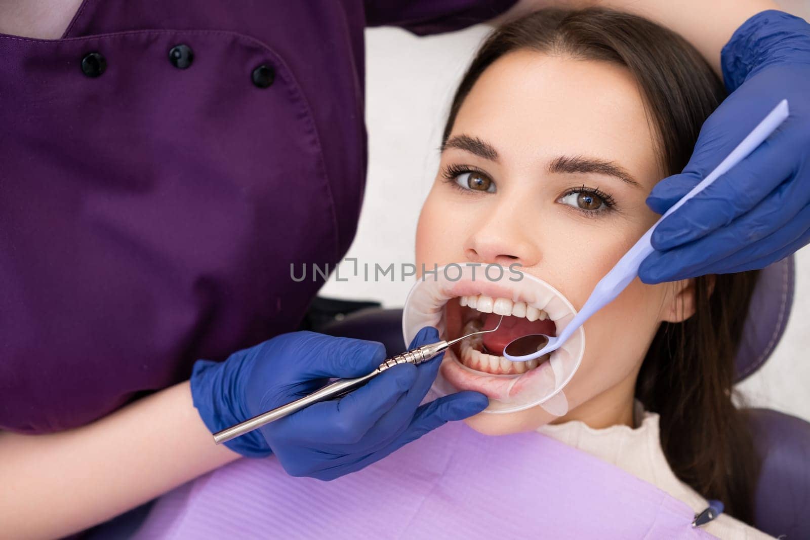 Portrait of brunette woman has checkup of teeth in denstist clinic by vladimka