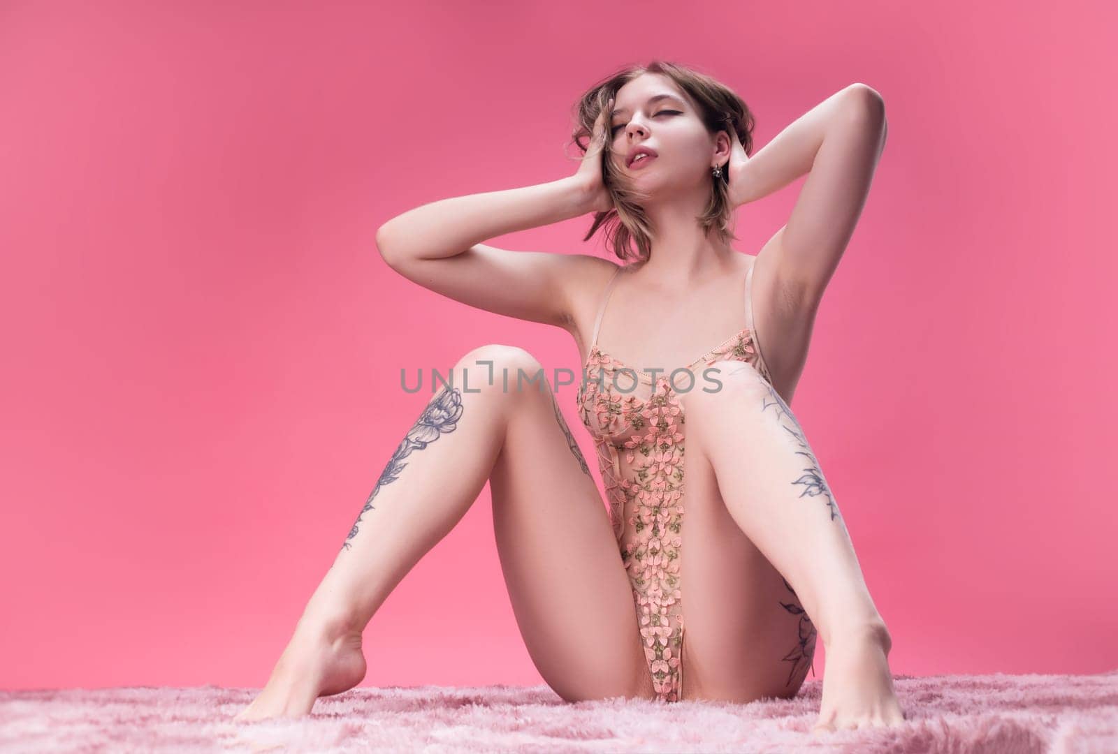 hot girl in beautiful lingerie on a pink background posing sexually freely emotionally by Rotozey