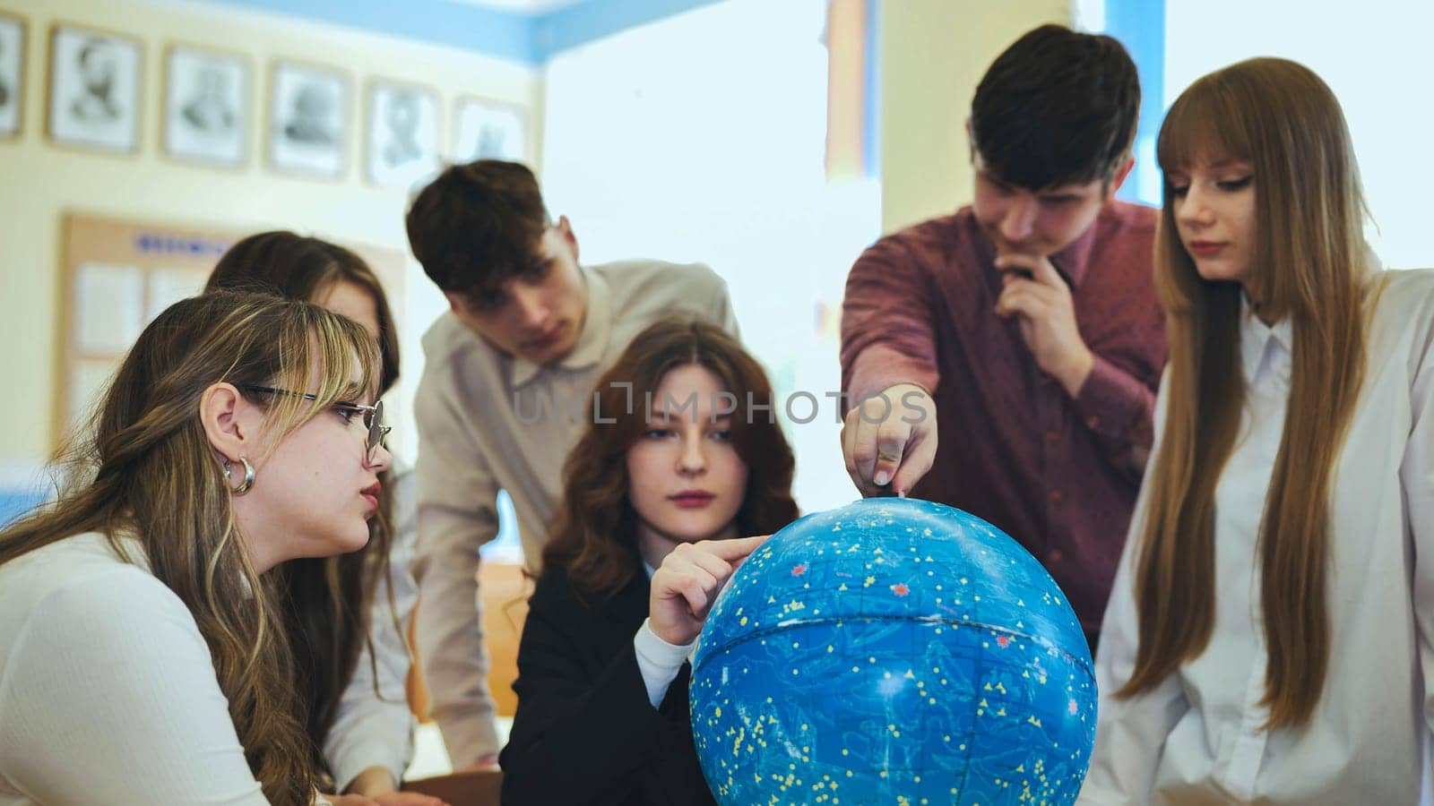 Students look at a globe of the starry sky in a classroom at school