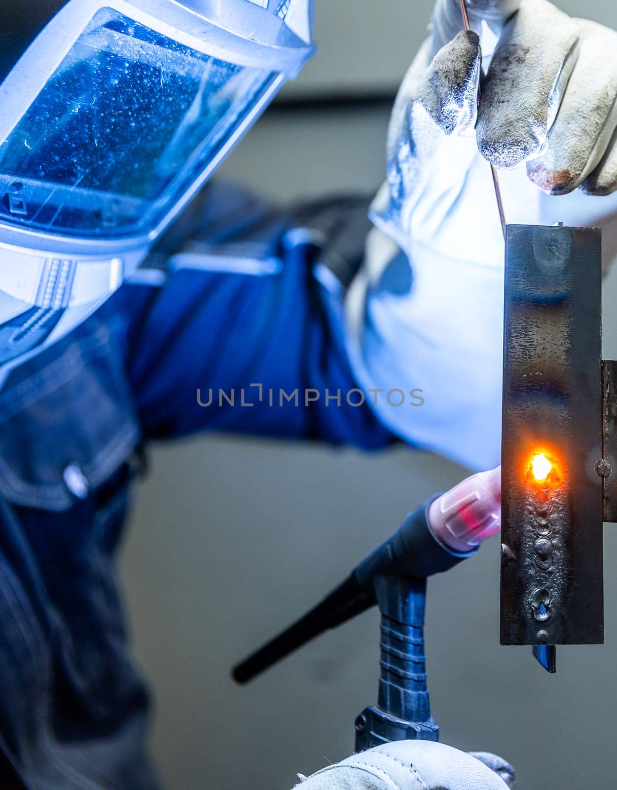 Welder worker welding pieces of metal in the industrial factory, heavy weld industry concept