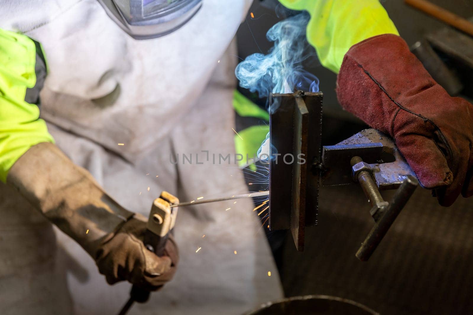 Industry worker welding a pieces of metal in the factory, weld concept by Kadula