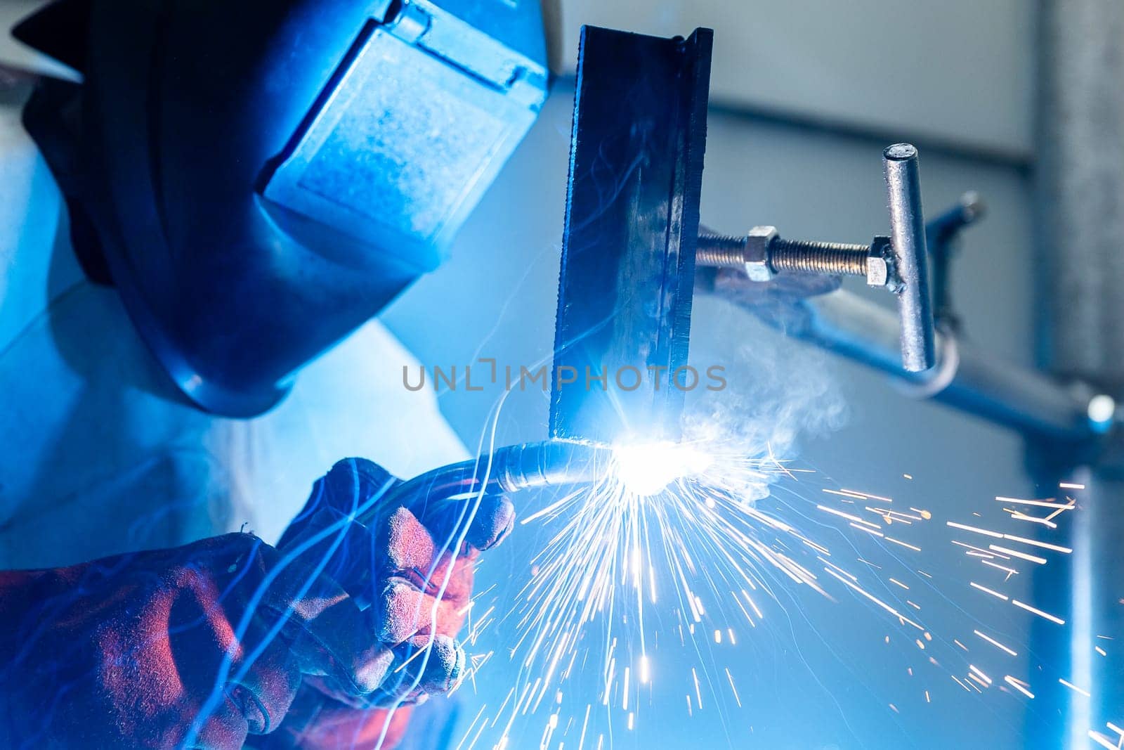 Welder worker welding pieces of metal in the industrial factory, heavy weld industry concept