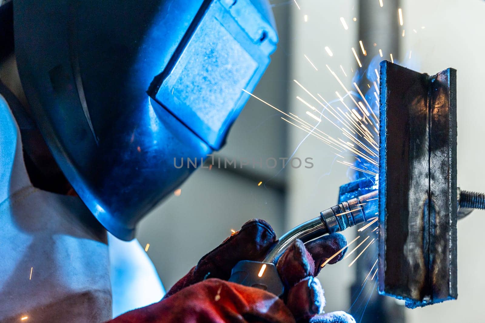 Welder worker welding pieces of metal in the industrial factory, heavy weld industry concept