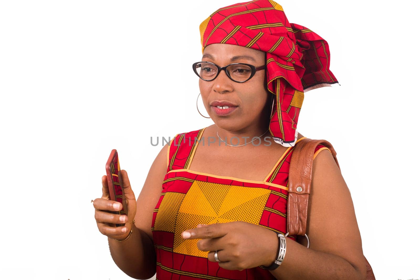 mature woman in loincloth standing on white background talking with mobile phone in hand.