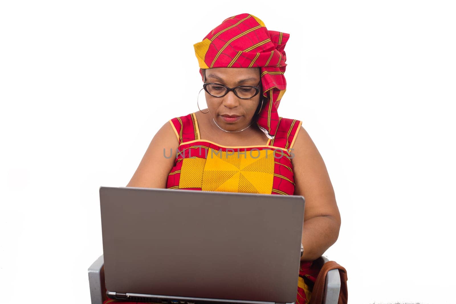 mature woman in loincloth on white background looking at laptop.