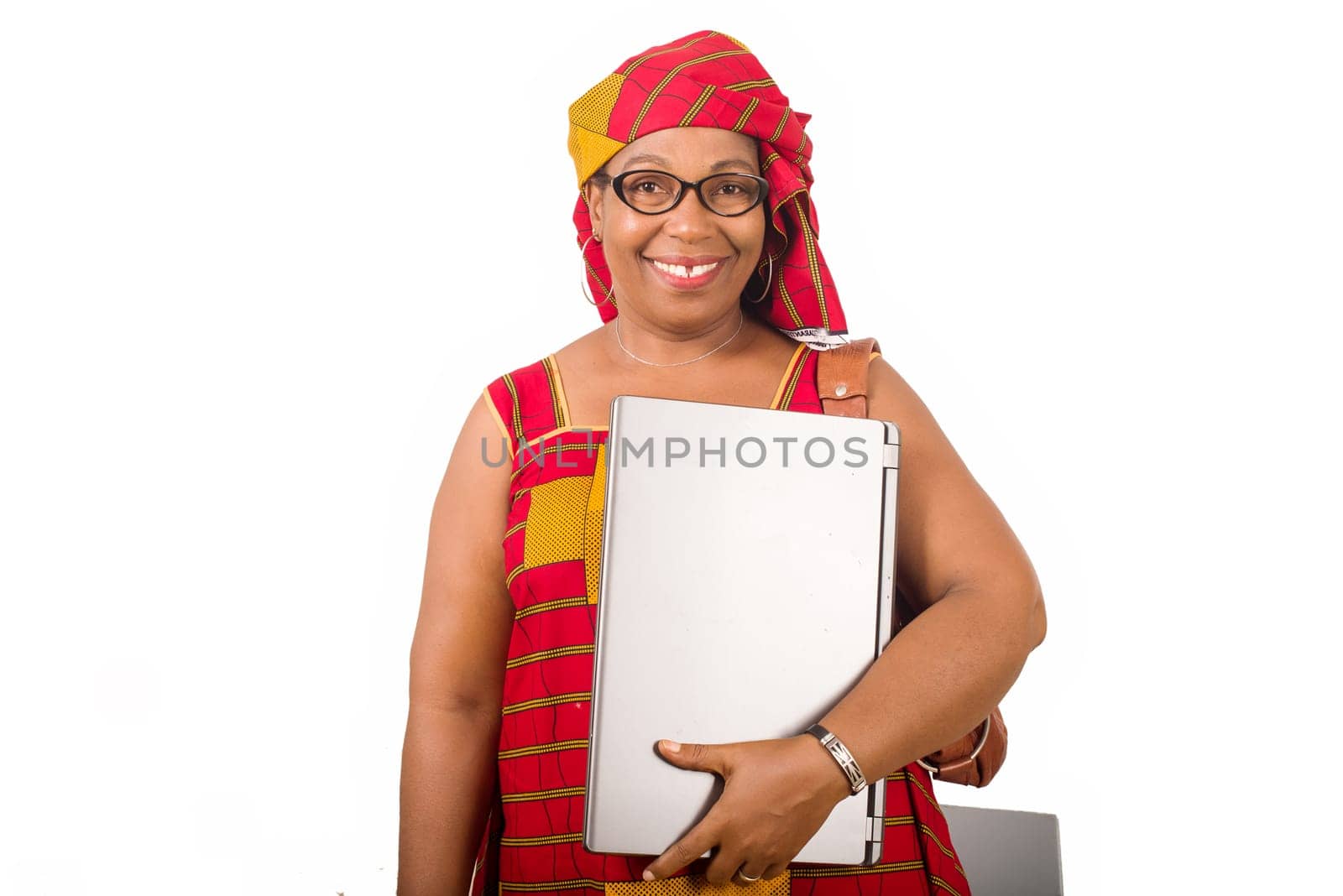 mature businesswoman standing on white background smiling with laptop in hand.