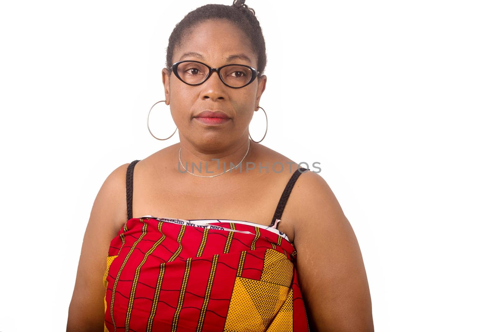 mature woman standing on white background looking at the camera.