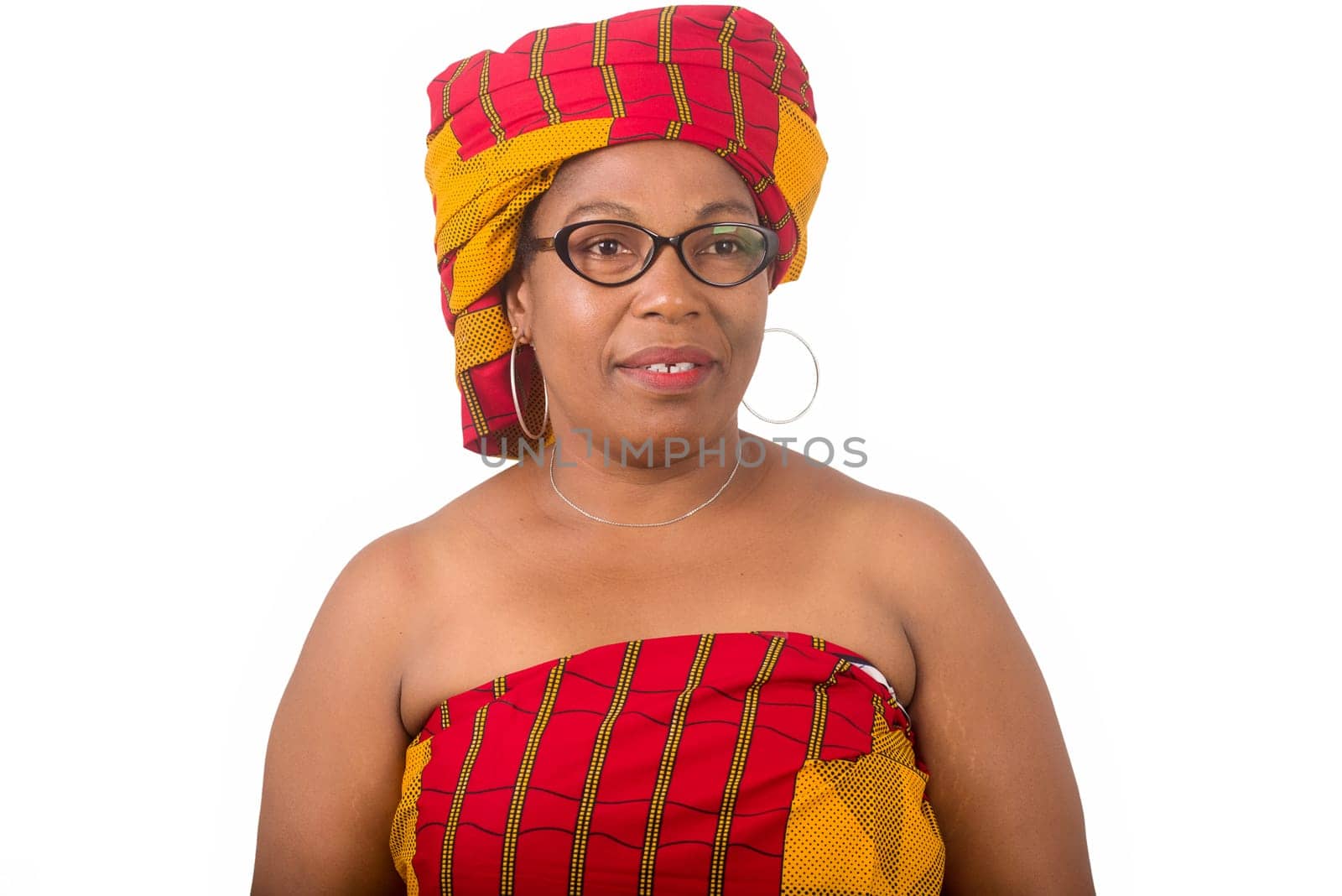 mature woman in glasses standing on white background looking at camera smiling.