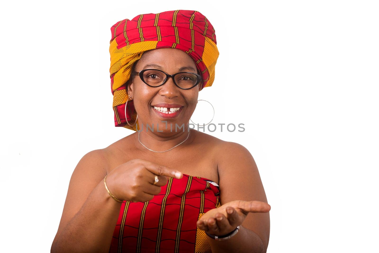 mature woman in glasses standing on white background gesturing and looking at camera smiling.