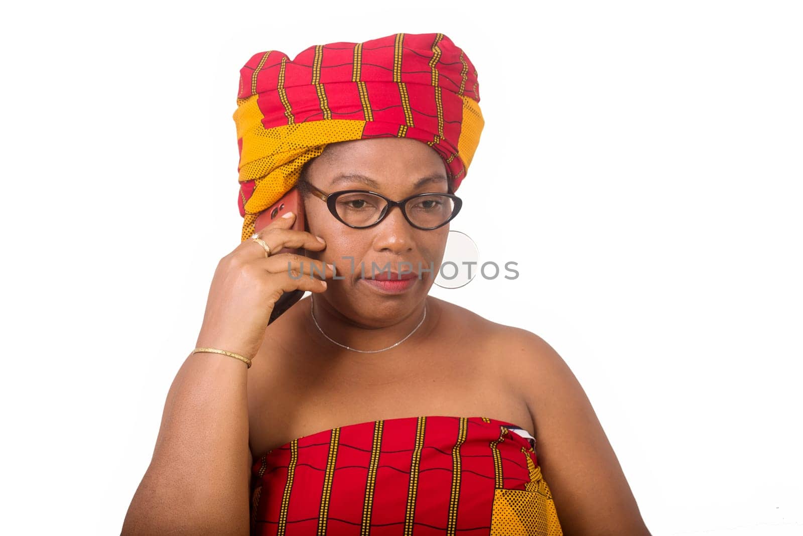 mature woman in glasses standing on white background communicating on cellphone.