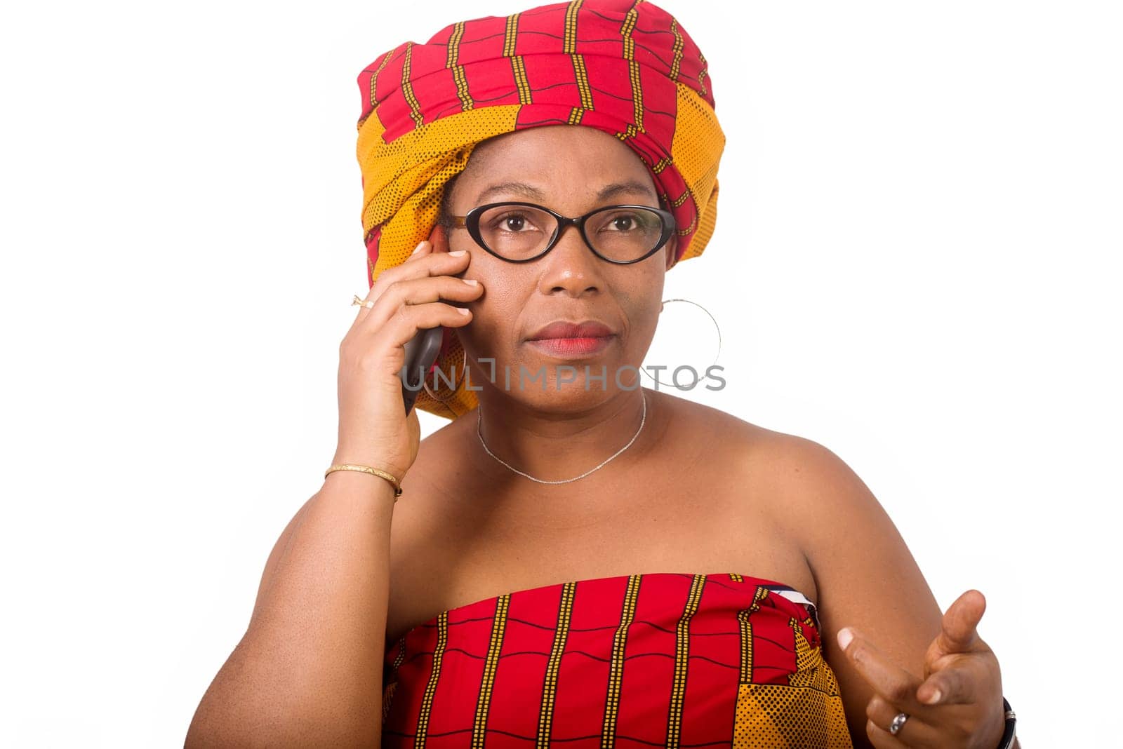 mature woman in glasses standing on white background communicating on cellphone.