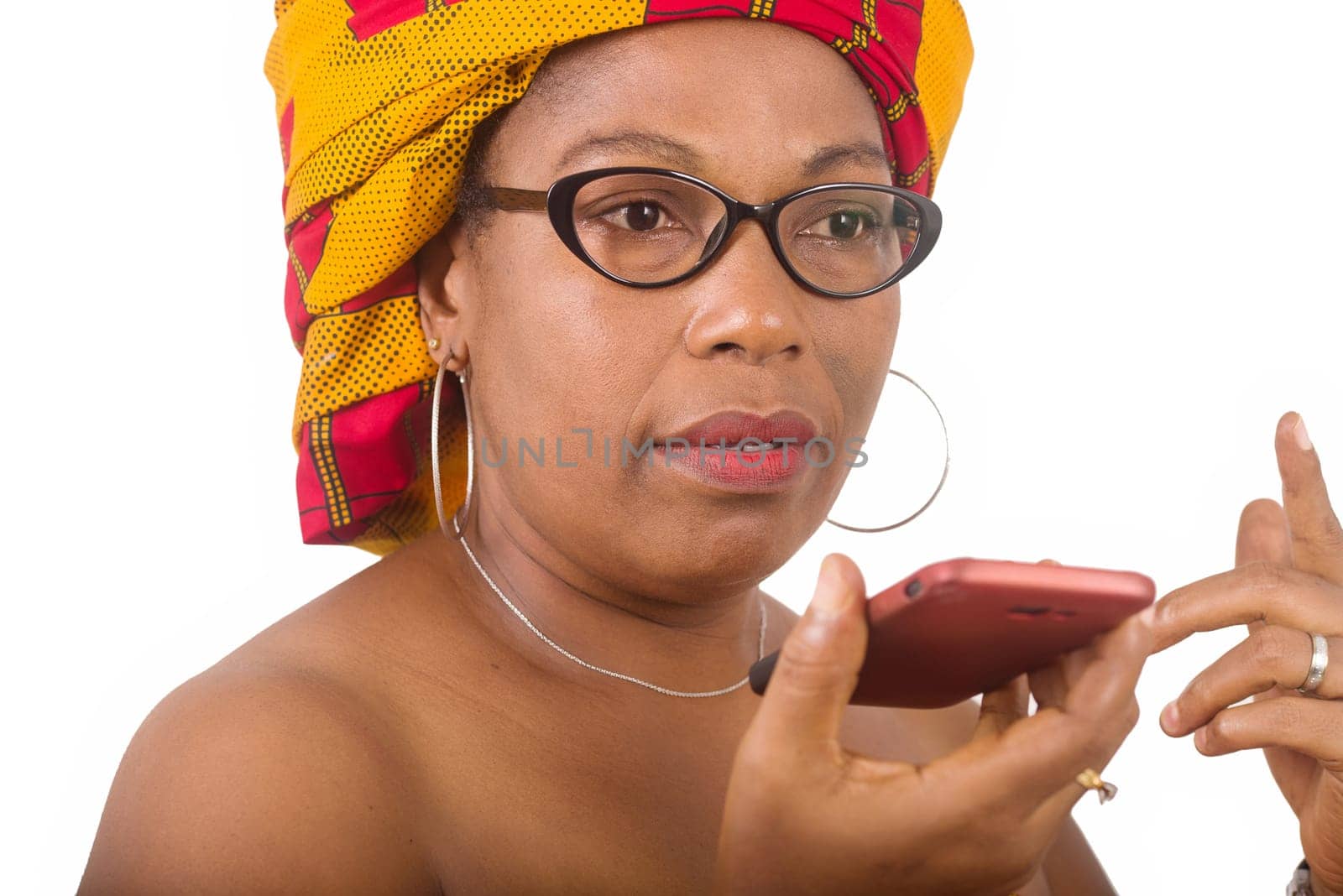 mature woman in glasses standing on white background communicating on cellphone.