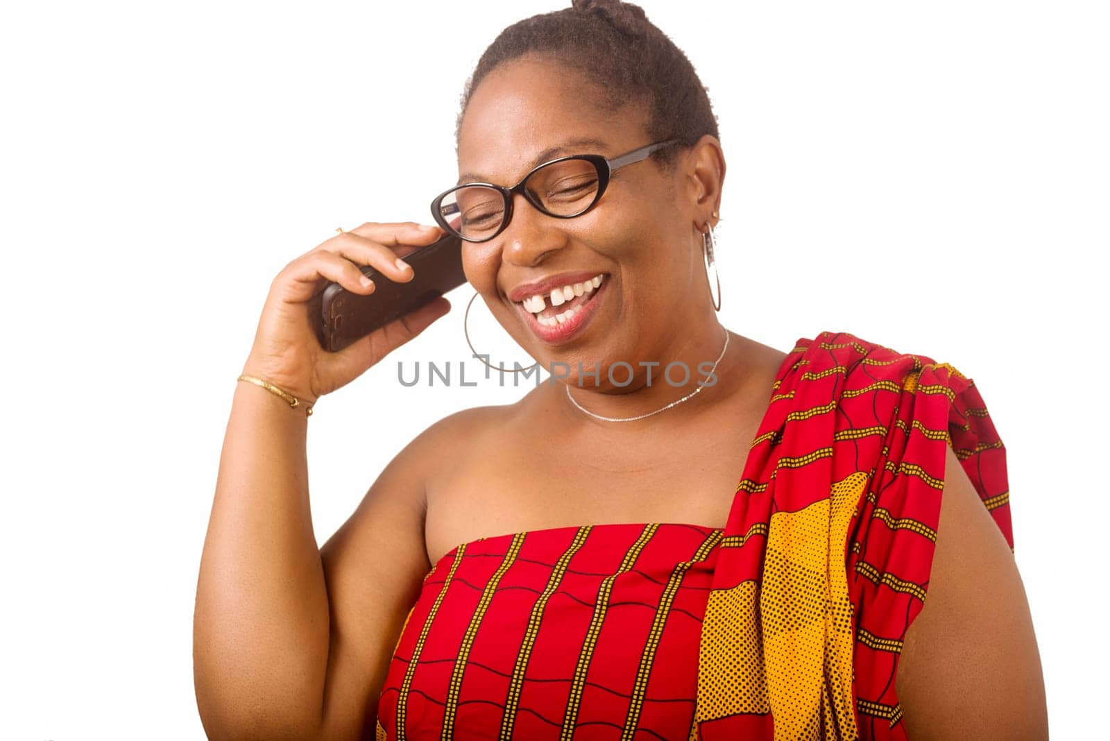 mature woman in traditional dress standing on white background communicating on cell phone laughing.