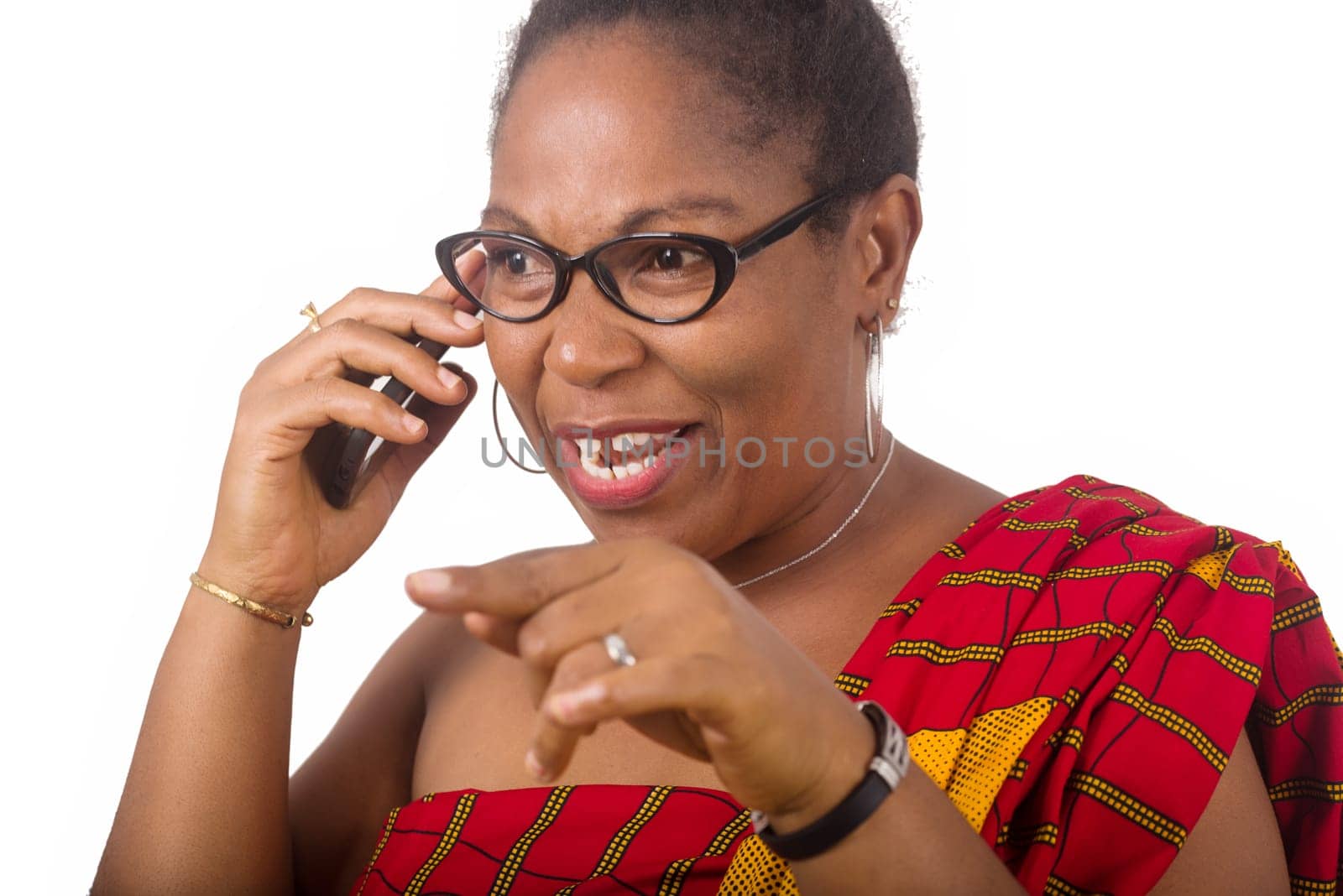 mature woman in traditional dress standing on white background communicating to mobile phone while smiling.