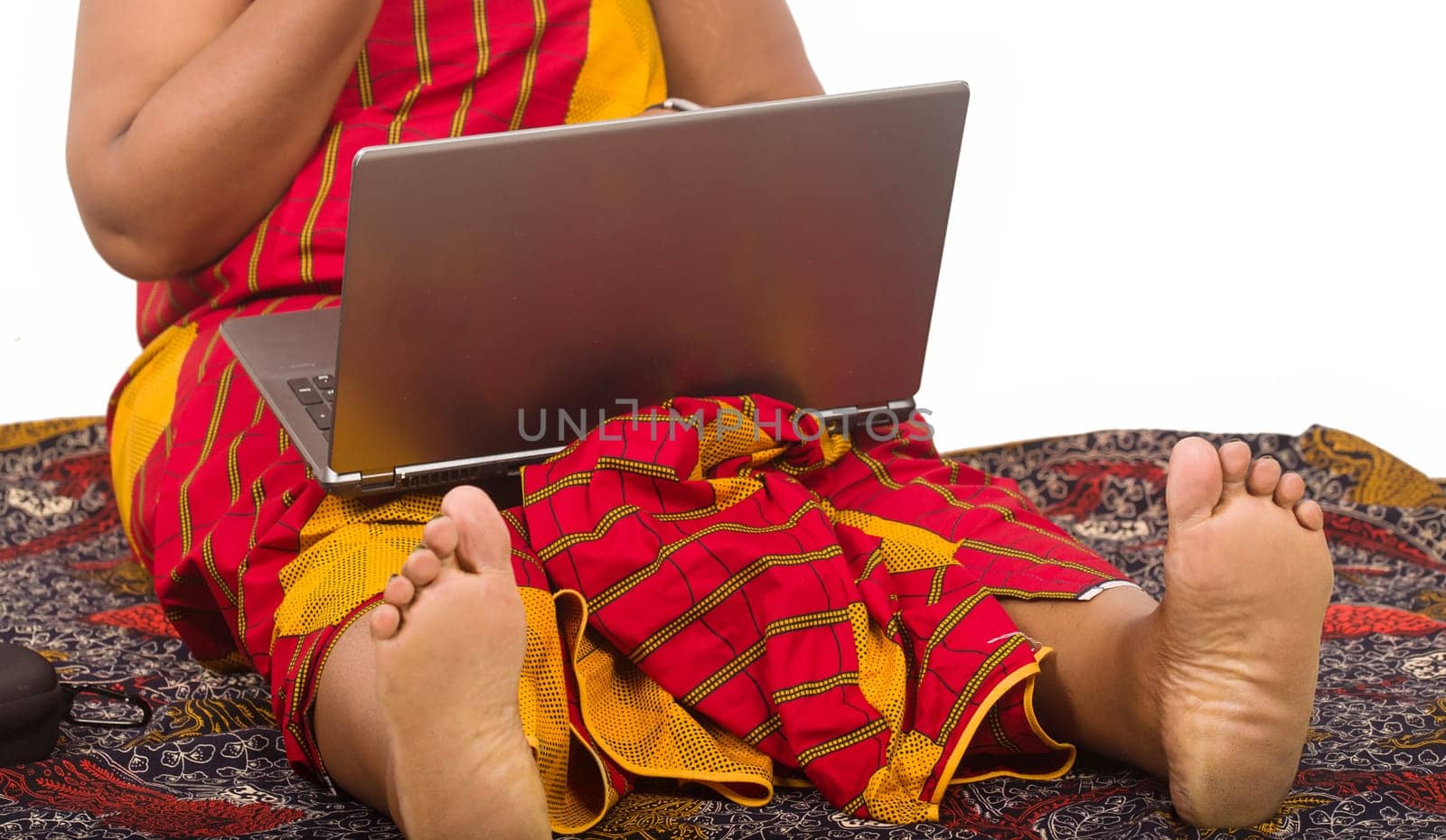 mature woman sitting on the floor in loincloth working with laptop.