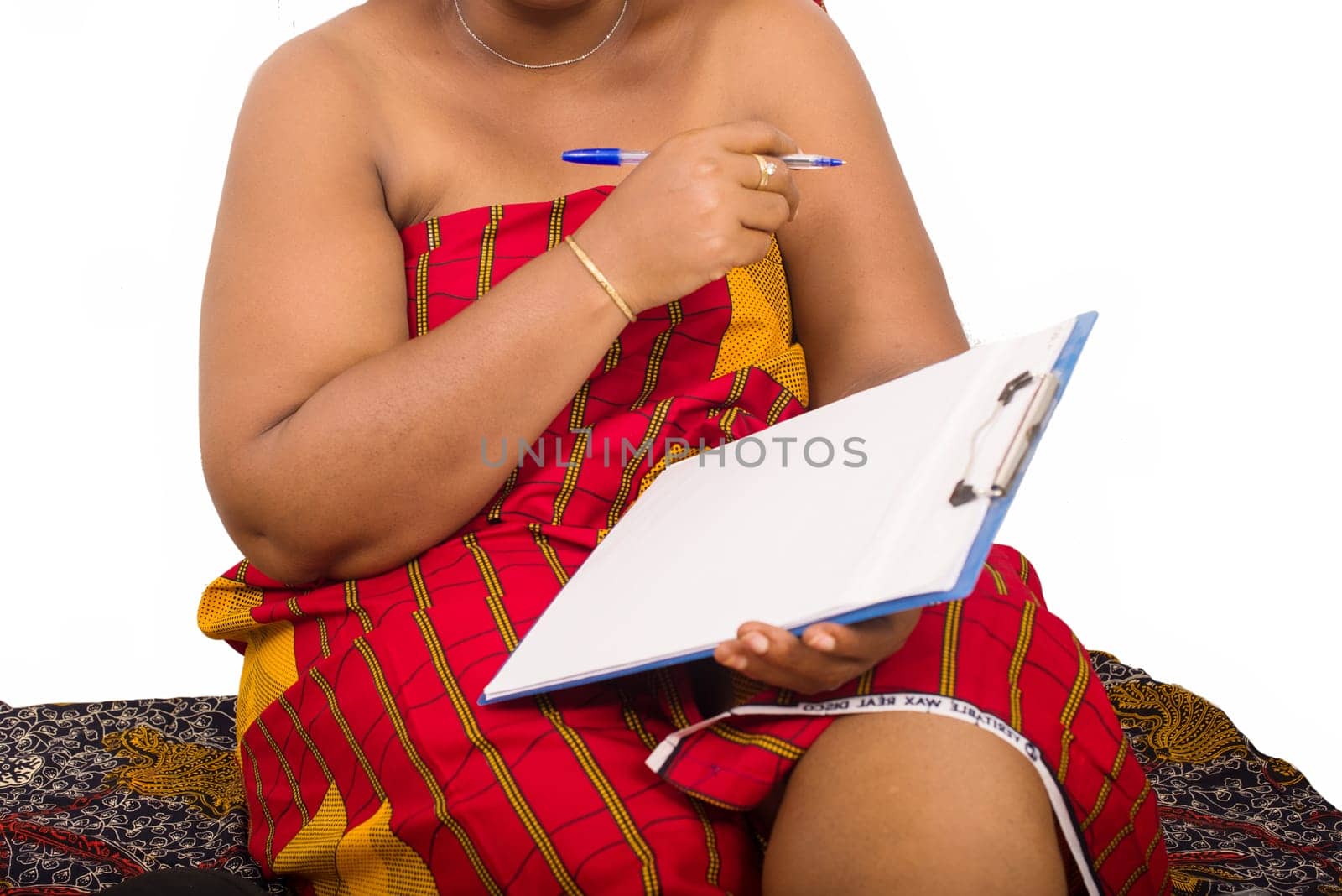 mature woman in loincloth sitting on white background with pad notes in hand.