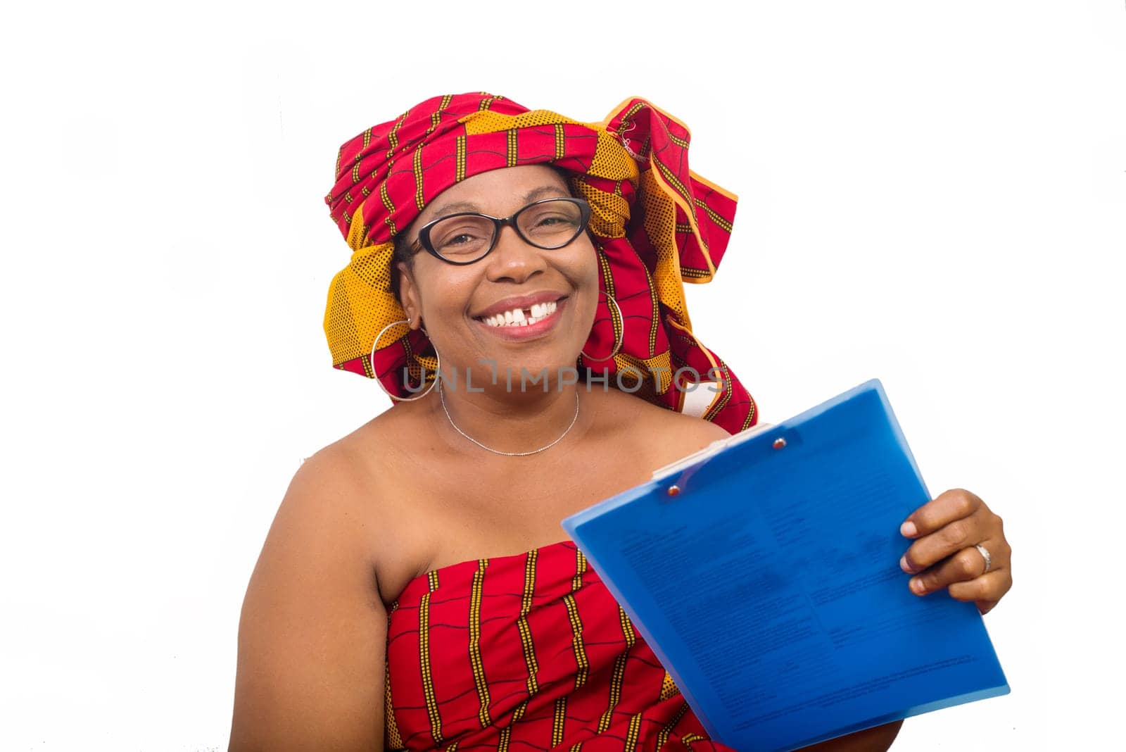 mature woman in loincloth sitting on white background showing a notepad and looking at camera smiling.