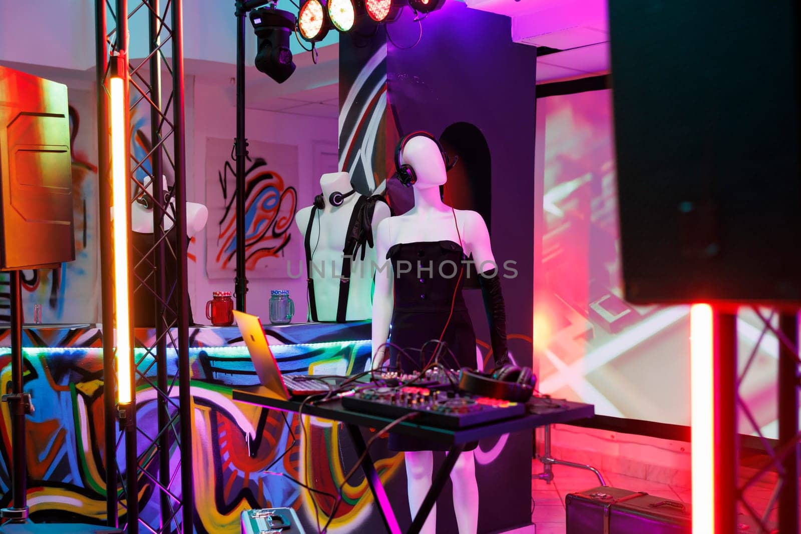 Musician sound mixer and mannequin in headset on stage in dark nightclub with spotlights. Dj controller equipment prepared for live performance and discotheque party in club