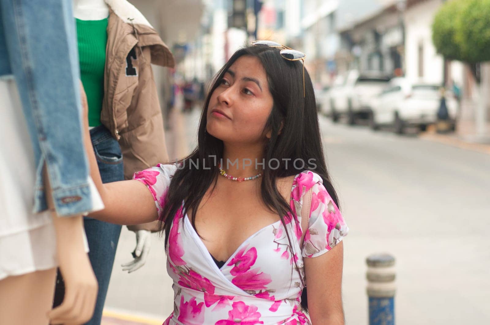 Young Woman tourist Shopping for Clothes on a Busy City Street During Summer by Raulmartin