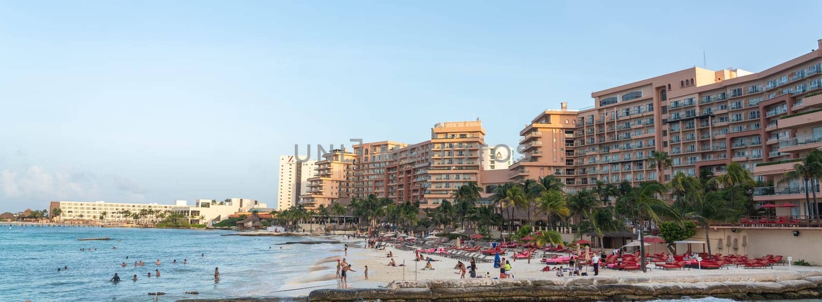 Blurry image of a beach with buildings by the water by Mariakray