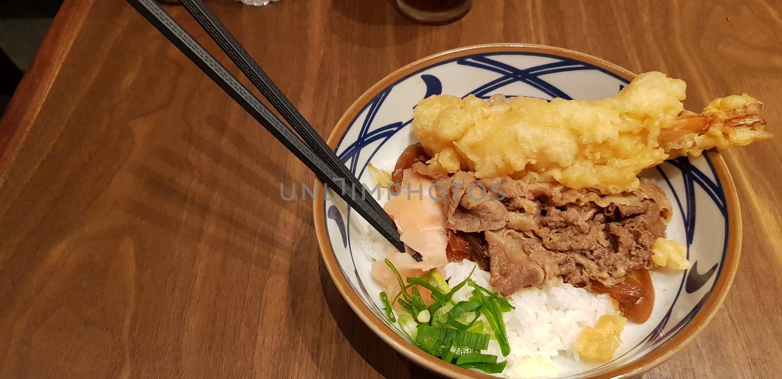 Japanese traditional food beef teriyaki with stickt rice and tempura shrimp sliced spring onion in a bowl