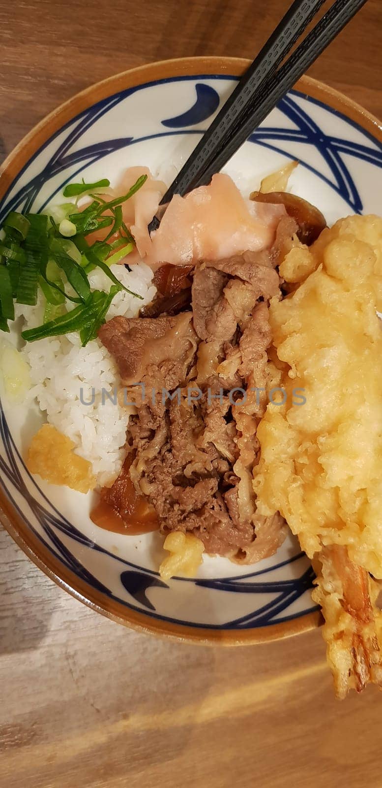 Japanese traditional food beef teriyaki with stickt rice and tempura shrimp sliced spring onion in a bowl