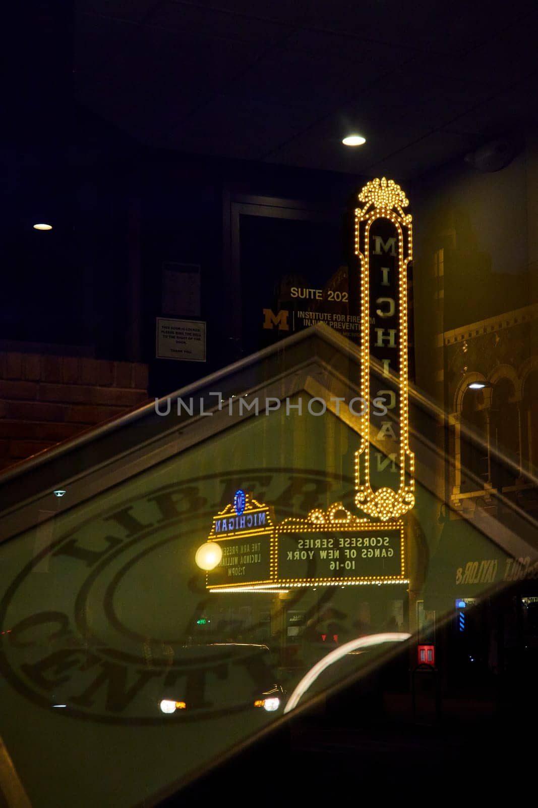 Illuminated Michigan Theater Marquee Reflects on Glass in Downtown Ann Arbor at Night