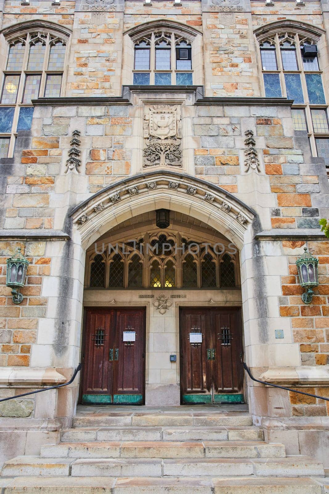 Historical Gothic-style entrance of the University of Michigan Law Quadrangle, showcasing intricate stone carvings and aged wooden doors