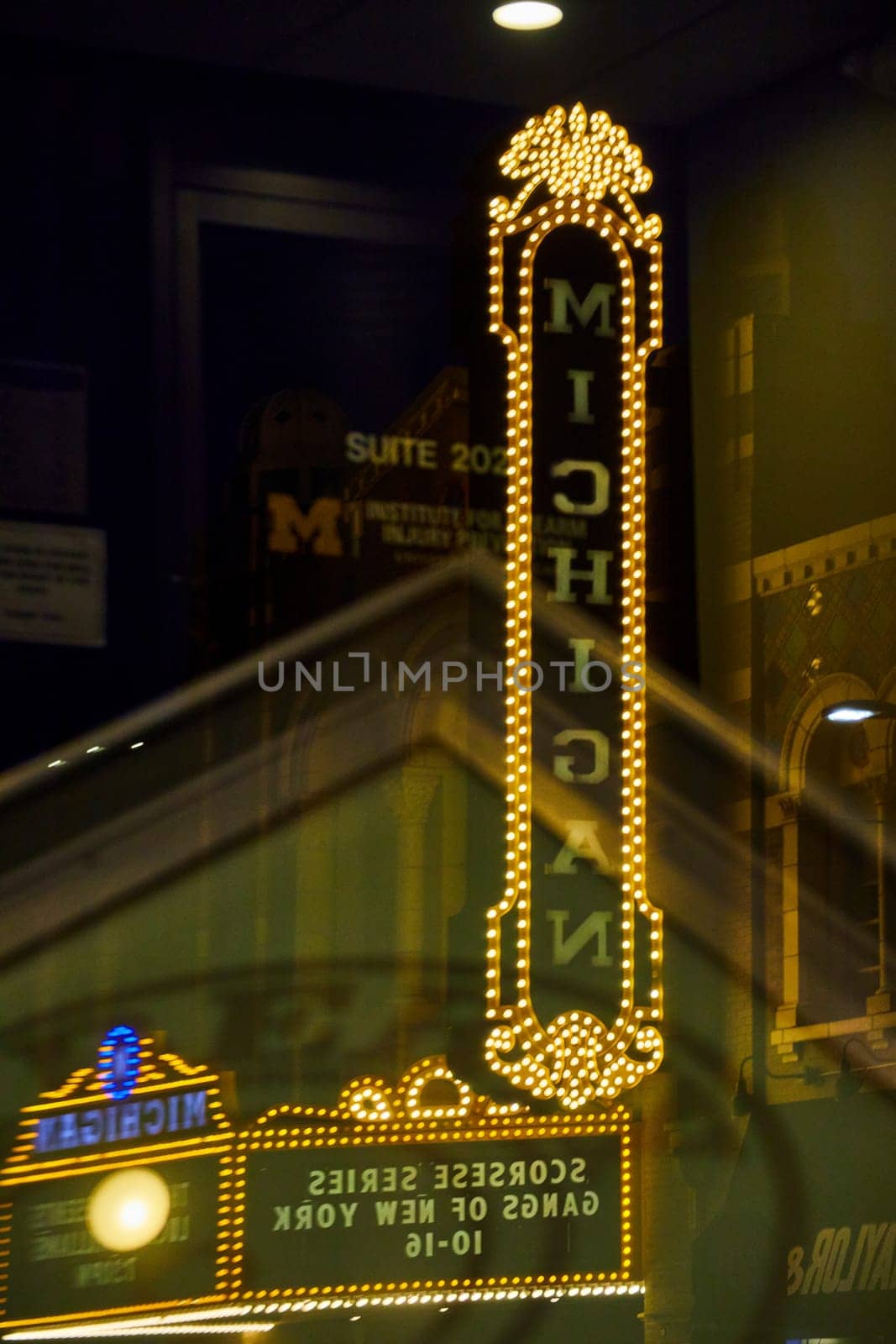 Brightly lit Michigan Theater sign illuminates the night in downtown Ann Arbor, reflecting city life in vibrant LED light.