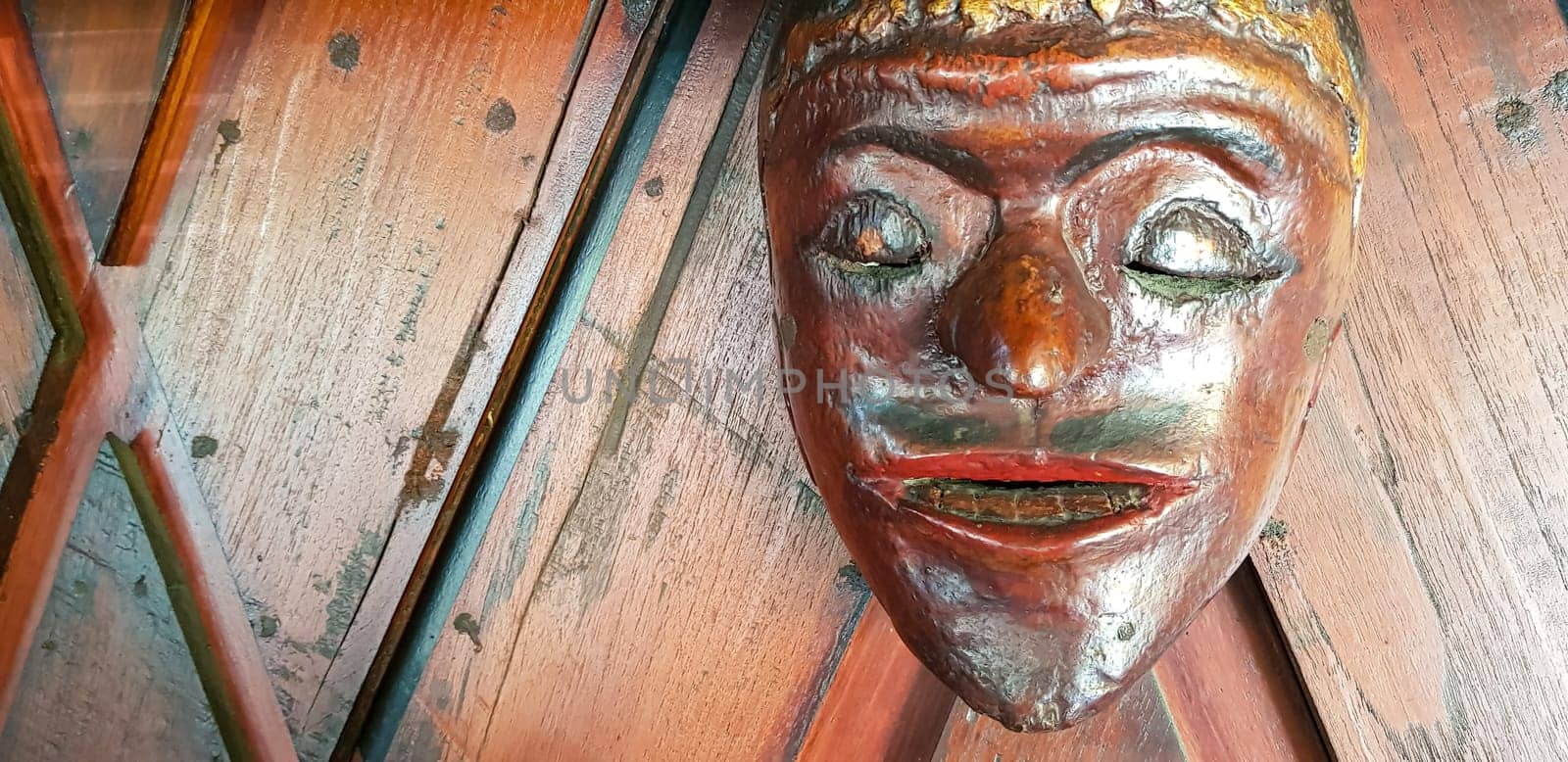 Mystical wooden mask and artworks in traditional retro Javanese style contains spirit of the dead