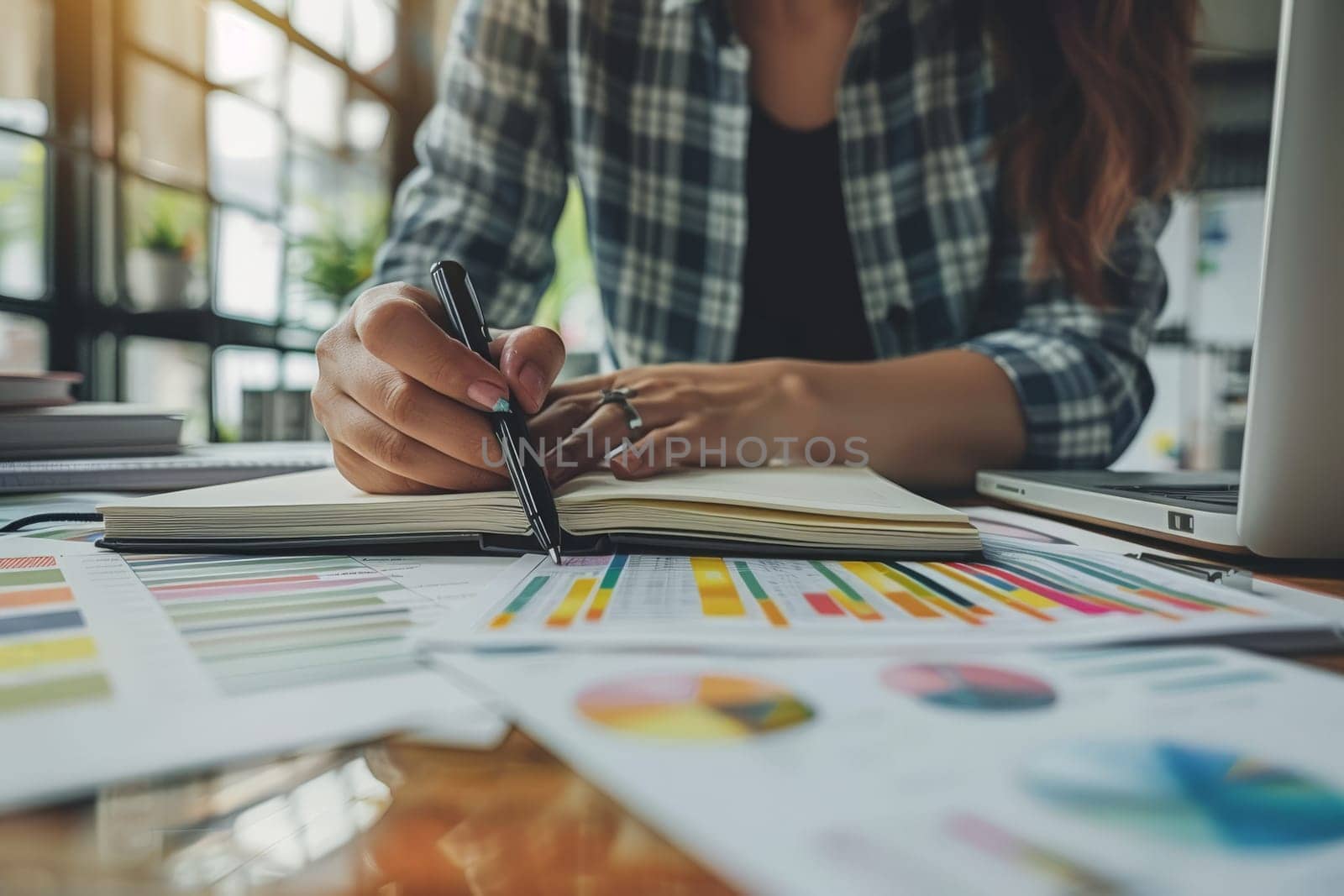 Selective focus on the businesswoman's hand, writing down tasks and note, office background.