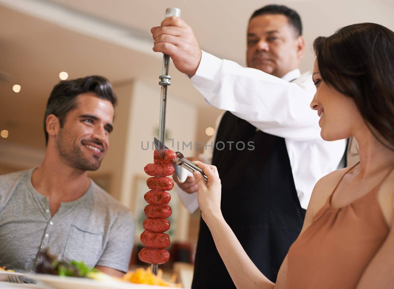 Food, date and romance with couple in restaurant together for celebration or eating espetada. Love, meat or dinner with happy young man and woman in fine dining hospitality establishment for service.