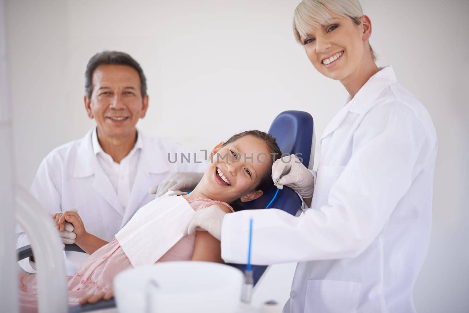 Portrait, dentist and technician with child in clinic for expert advice, orthodontics and medical health. Dental medicine, healthcare and professional man with girl, woman and oral service in office.