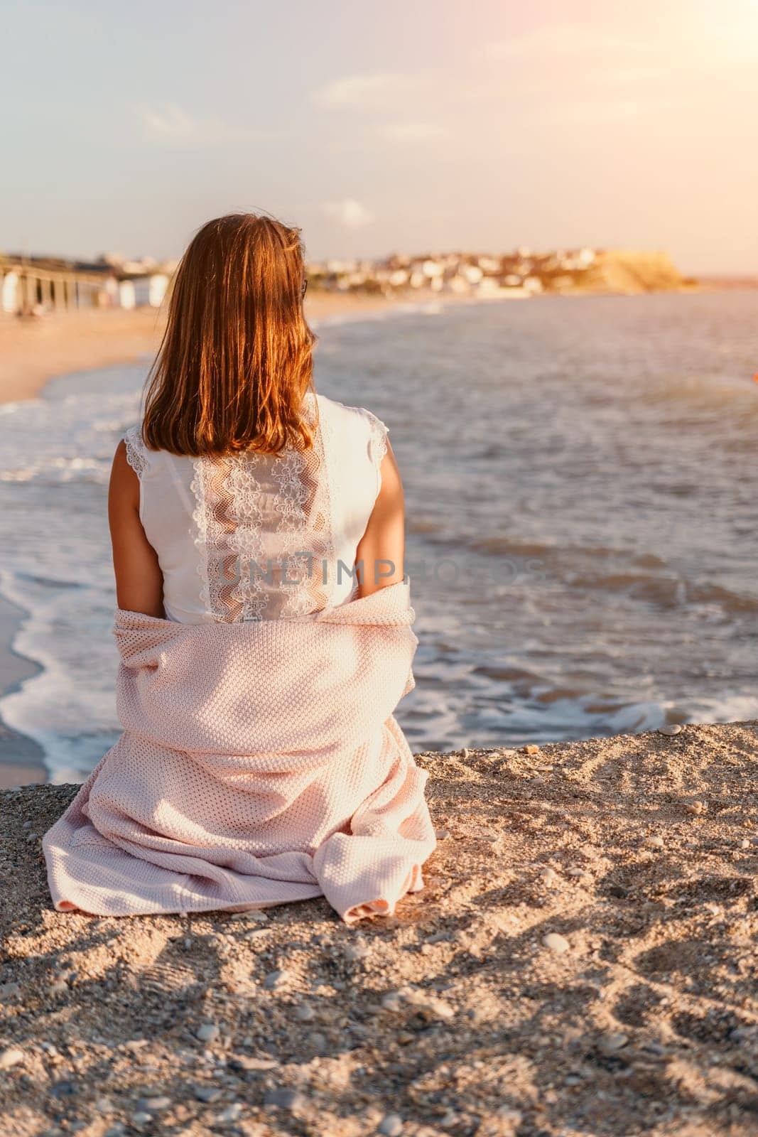 Woman travel sea. Young Happy woman in a long red dress posing on a beach near the sea on background of volcanic rocks, like in Iceland, sharing travel adventure journey