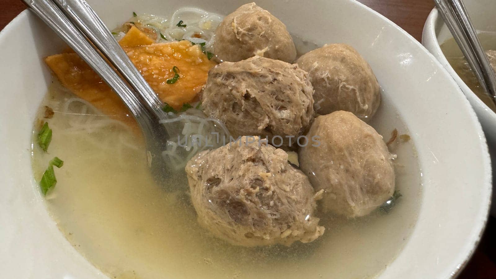 super delicious, tender and juicy and spicy bites of beef tendon meatballs in a bowl in Indonesian street food