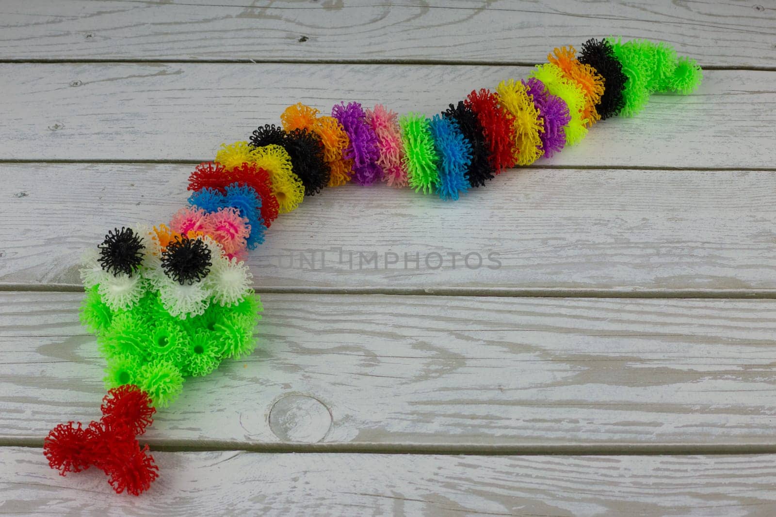 Toy snake made of multi colored burdocks, fluffy velcro construction set for children development