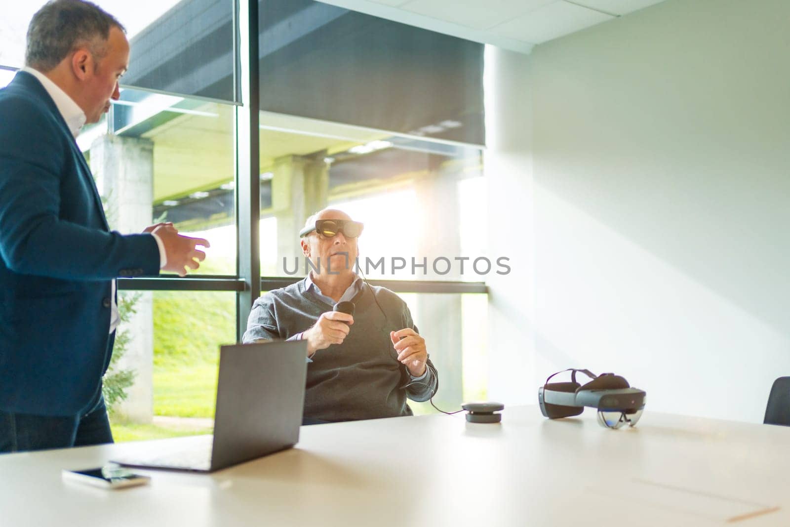 Businessman talking with client during a demo of vr goggles by Huizi