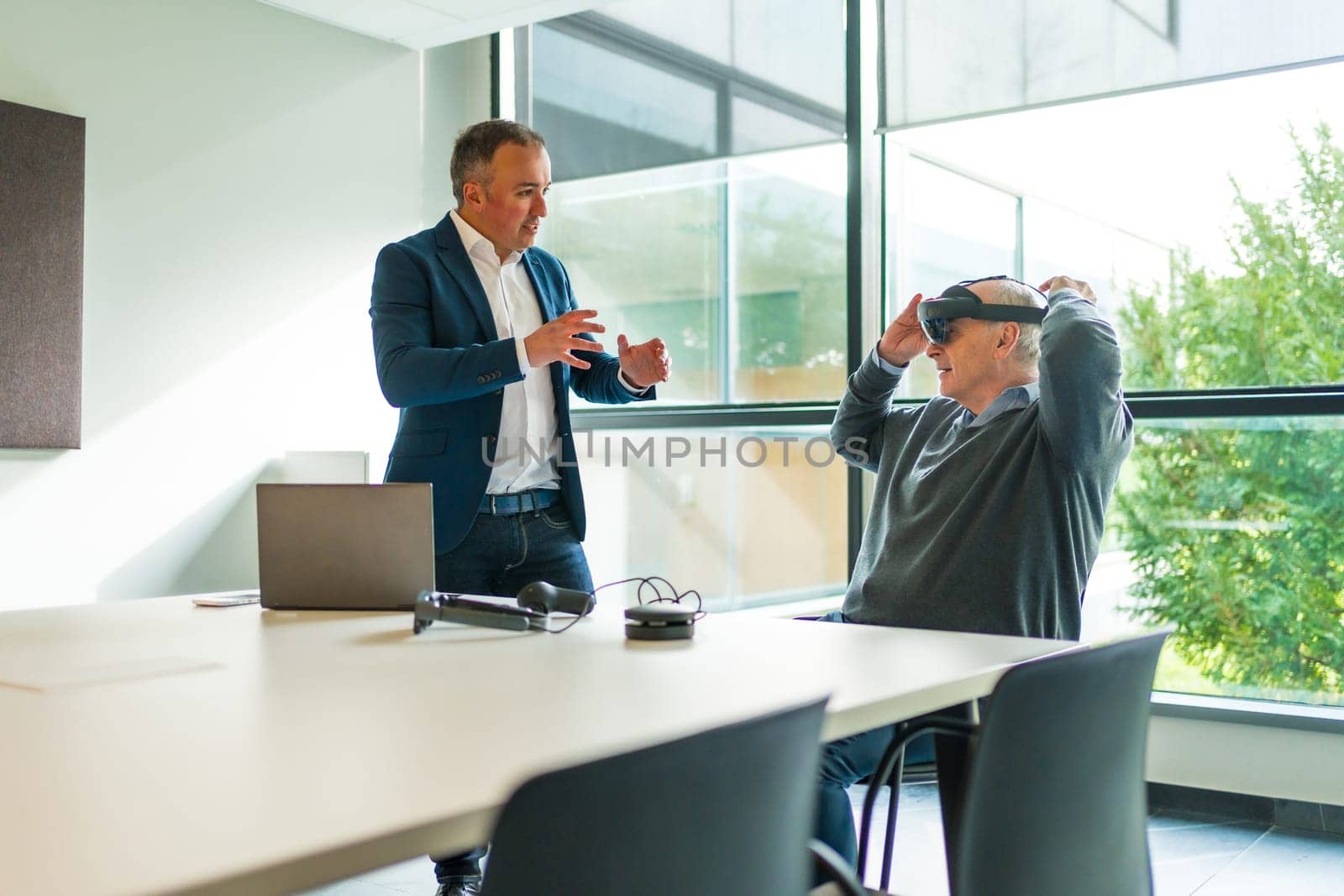 Businessmen during a demo of a new augmented mixed vision reality goggles in the office with a client
