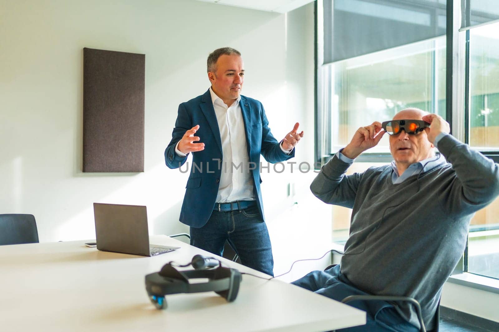 Businessman presenting a innovative mixed reality goggles to a client by Huizi