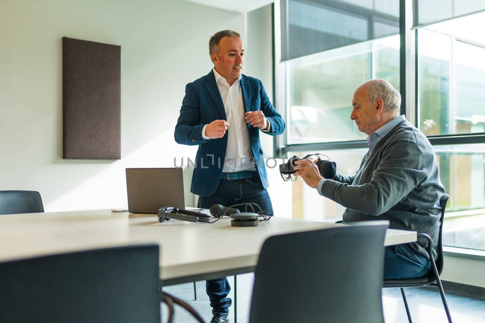 Businessman presenting a new virtual reality goggles to a client by Huizi