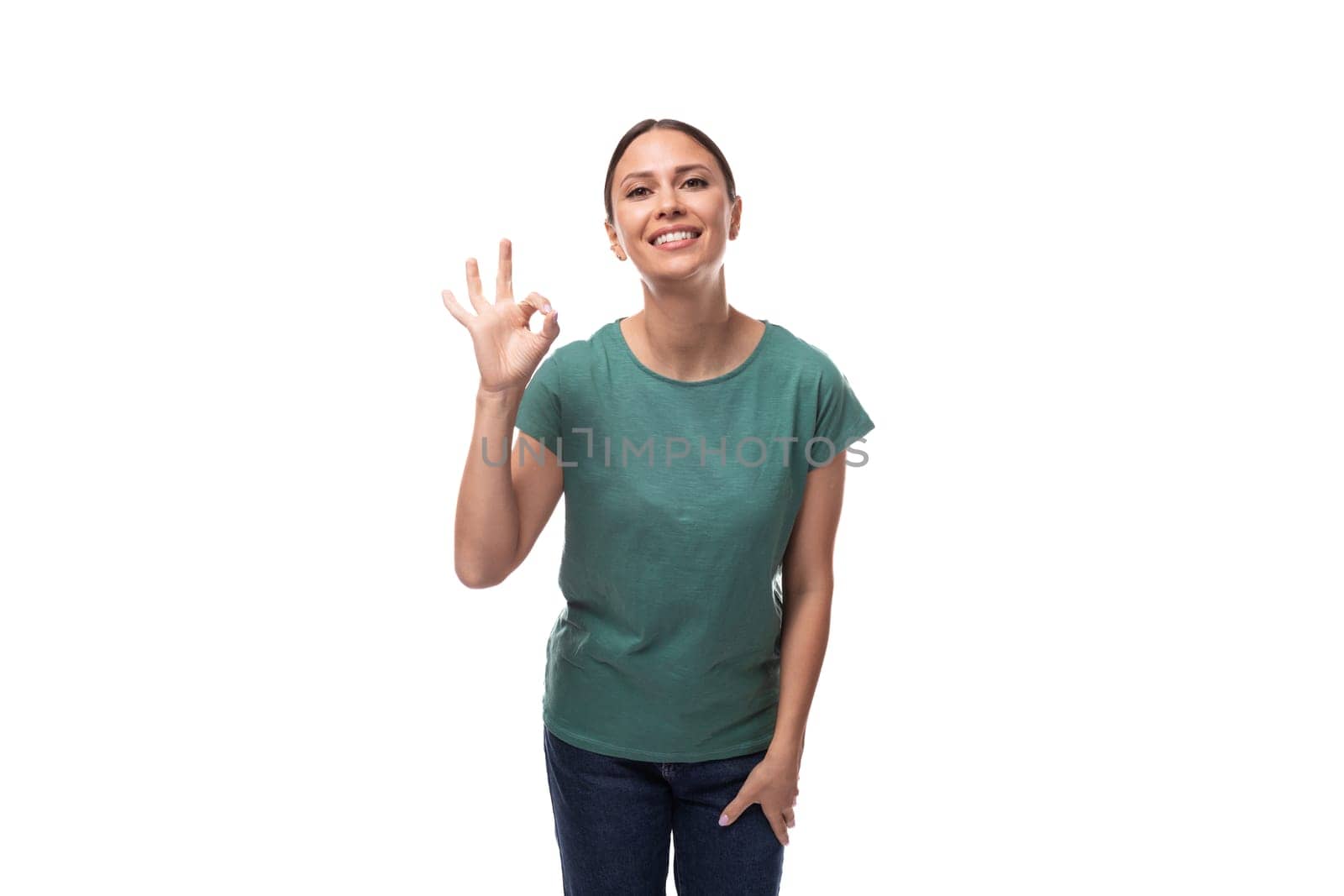 charming cute friendly slim young brunette woman dressed in a green t-shirt smiling on a white background.